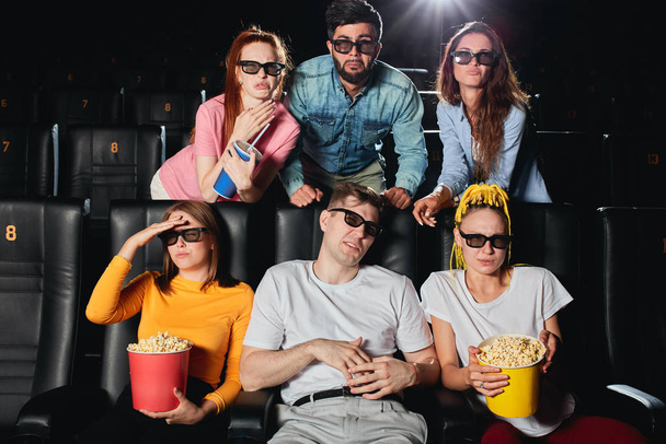 Surprised irritated terrified men and women watching movie - Fotó, kép