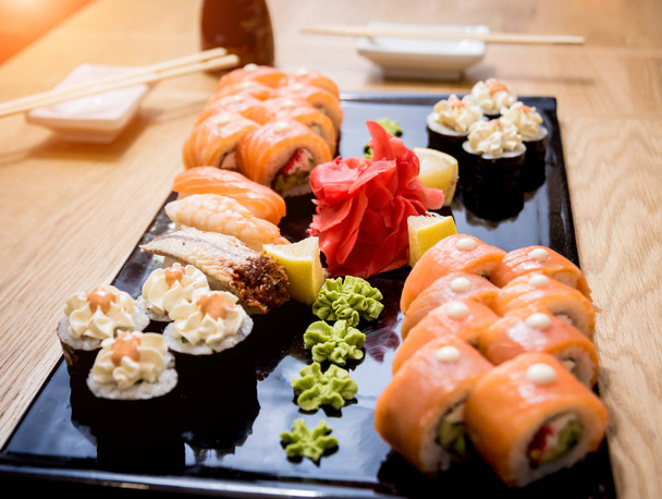 Sushi pronto. Rolos com salmão, enguia e caviar vermelho em uma chapa de madeira. Restaurante
. - Foto, Imagem