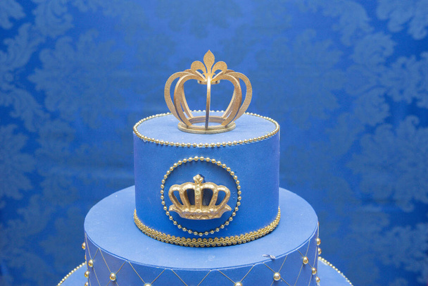 Falešný modrý narozeninový dort s korunou nahoře. Malý princ nebo královské téma. Zdobený stůl na oslavu dětských narozenin. Close up of decor party. - Fotografie, Obrázek