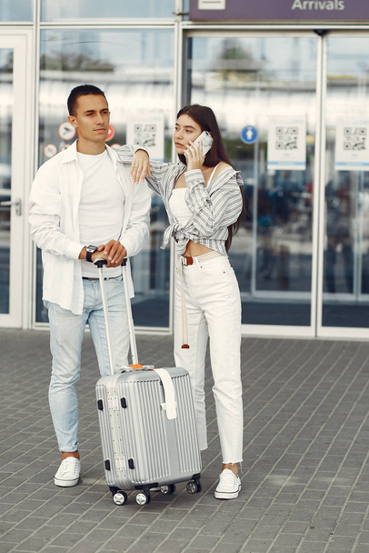 Beautiful couple standing near the airport - Fotó, kép