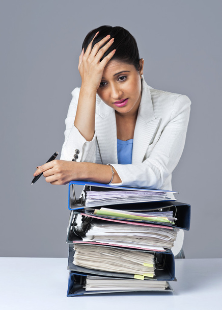 Businesswoman leaning on a stack of files - Fotoğraf, Görsel