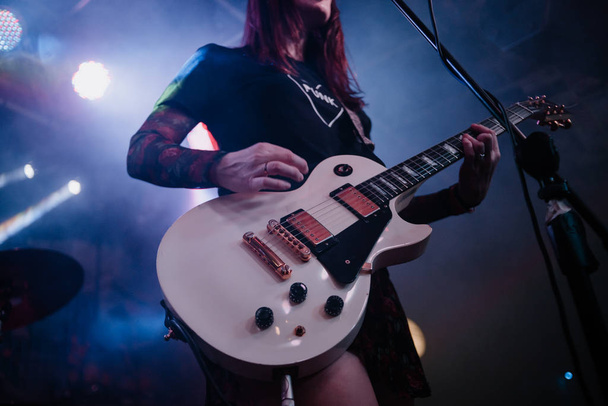 Девушка играет на гитаре и поет на концерте
 - Фото, изображение