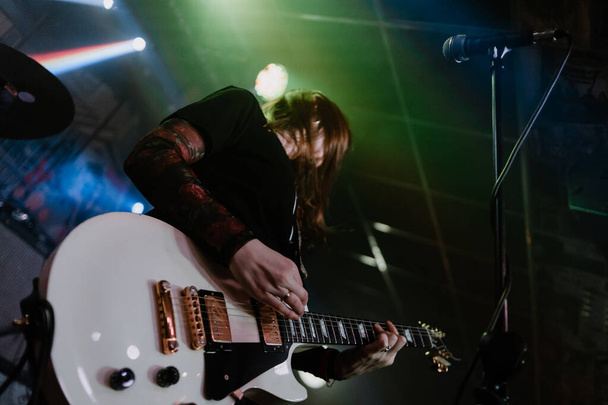 A punk girl playing a guitar in a concert - Foto, imagen