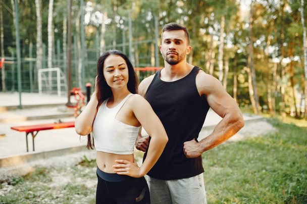 Beautiful couple training in a summer park - Foto, afbeelding