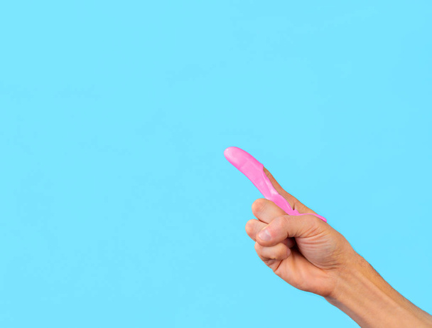 δάχτυλο σε ροζ χρώμα δείχνει σε μπλε φόντο - Φωτογραφία, εικόνα