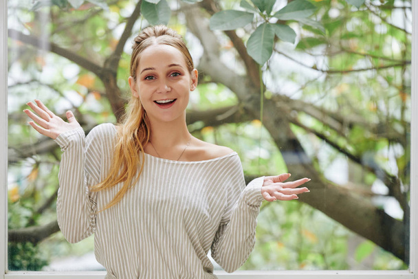 Portrait of excited happy young woman making hand gesture and looking at camera - Photo, Image