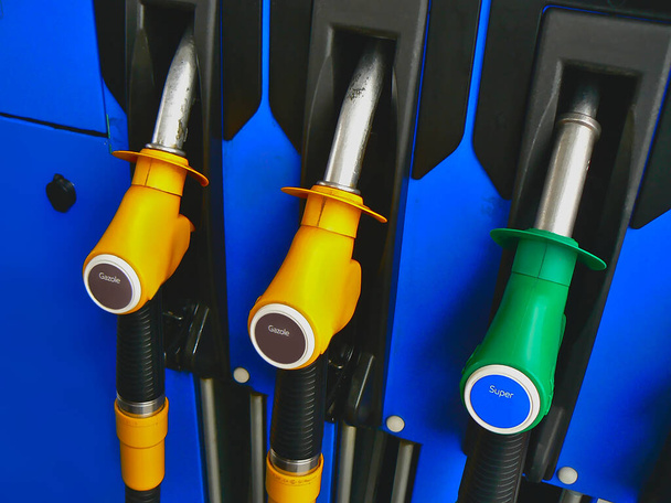 Three diesel and super unleaded 95 pumps, yellow and green, at a service station - Fotoğraf, Görsel