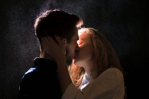 Портретное фото сексуальной молодой пары в предварительном поцелуе под каплями воды
 - Фото, изображение