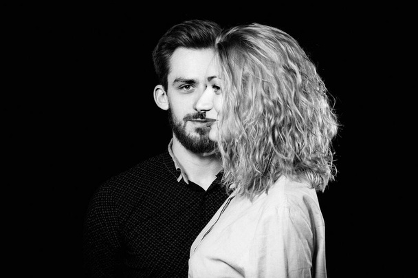 retrato foto de una sexy pareja joven hombre y mujer en una cara, sobre fondo negro
 - Foto, Imagen