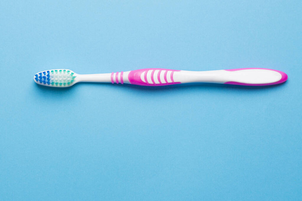 λευκή ροζ οδοντόβουρτσα σε μπλε φόντο - Φωτογραφία, εικόνα