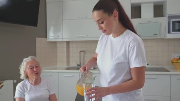Brunette woman pouring juice into glasses. - Materiał filmowy, wideo