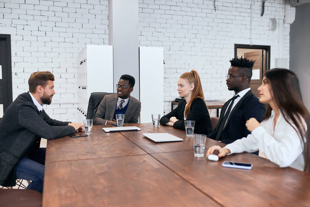 Mezinárodní skupina podnikatelů sedí společně u stolu - Fotografie, Obrázek