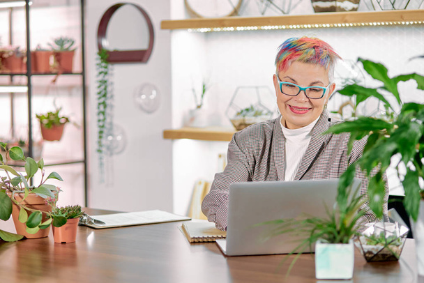 executive senior business lady sitting at office desk using her laptop - Photo, Image