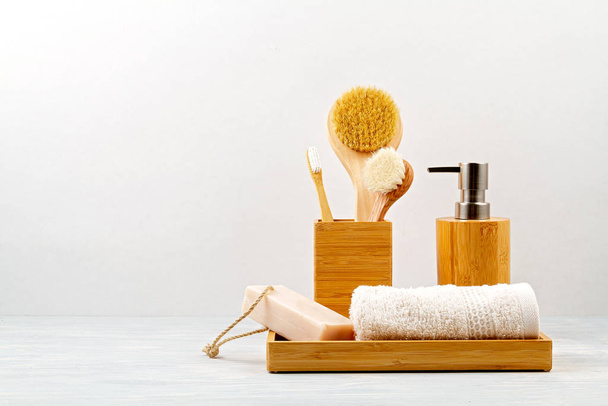 Bamboo acessories for bath - bowl, soap dispenser, brushes, tooth brush, towel and organic dry shampoo for personal hygiene - Foto, afbeelding