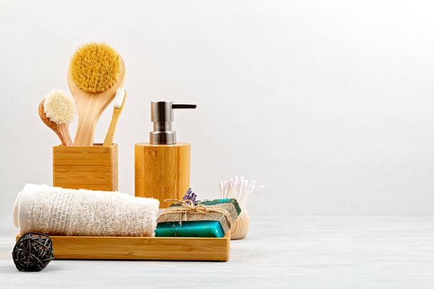 Accessoires en bambou pour le bain - bol, distributeur de savon, brosses, brosse à dents, serviette et shampooing sec bio pour l'hygiène personnelle
 - Photo, image
