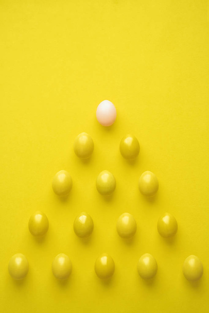 Pattern Of Chicken Eggs In Pyramid Shape Against Yellow Background - Foto, immagini