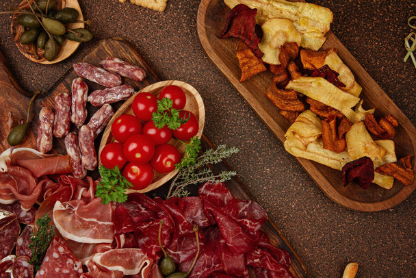 Appetizers table with differents antipasti, cheese, charcuterie, snacks and wine. Sausage, ham, tapas, olives, cheese and crackers for buffet party. - Photo, Image