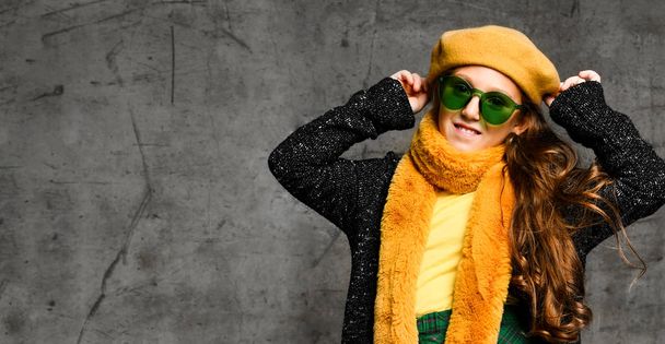 Portrait of young smiling girl model in stylish casual clothing, bright yellow accessories and green sunglasses - 写真・画像