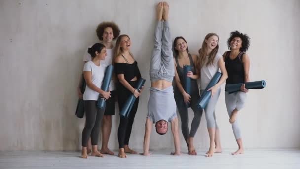 Multiethnic sporty people in sportswear standing near wall posing indoors - Footage, Video