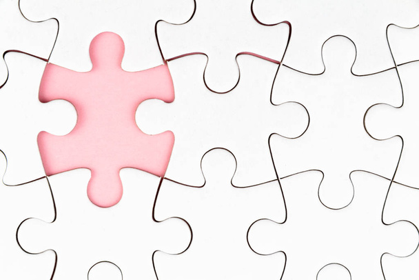 White puzzle over pink backround with missing pieces. Incomplete elements, solution search concept - Foto, Imagem