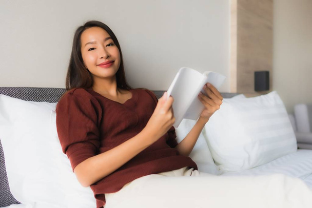 Портрет красивые молодые азиатские женщины, читающие книгу на кровати
 - Фото, изображение