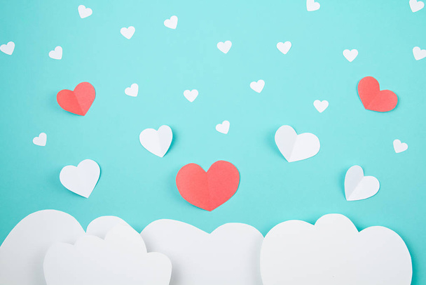 White paper hearts and clouds over the tuquiose background. Sainte Valentine, mother's day, birthday greeting cards, invitation, celebration concept - Photo, Image