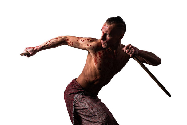 Sportowiec we krwi, z japońskim mieczem, pokazuje techniki walki. Izolacja na białym tle. - Zdjęcie, obraz