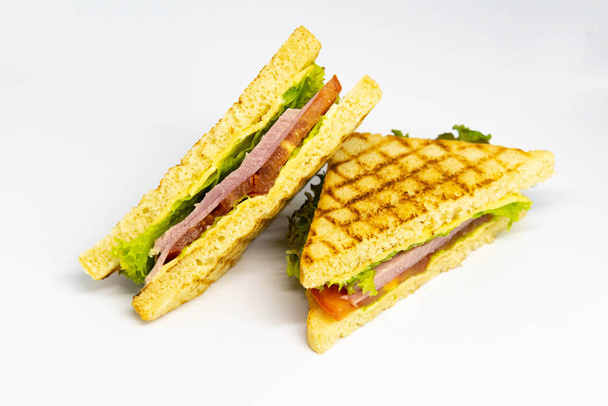 Sandwich con jamón, queso, tomate, lechuga y pan tostado
. - Foto, Imagen