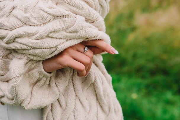 Young woman in a knitted sweater and with a ring on her finger - Foto, afbeelding