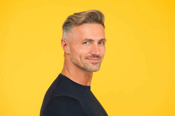 handsome unshaven man. mature macho man yellow background. male hairstyle fashion. skin facial care. hair fashion for men. barbershop concept. confident and smiling guy. portrait of charisma - Fotoğraf, Görsel