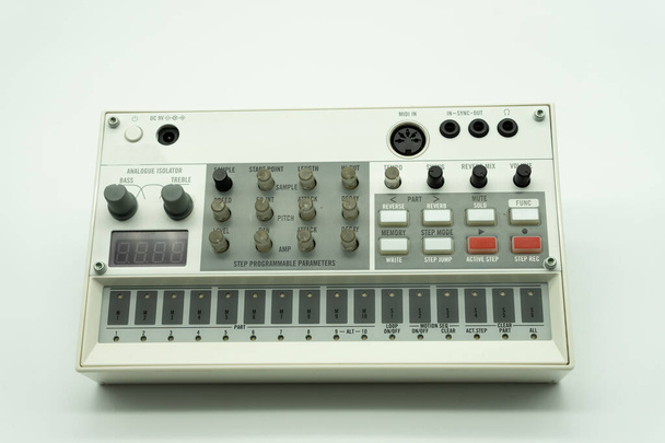 Fehér analóg szintetizátor mintavevő gombokkal és kulcsokkal. Hangberendezés zenei gyártáshoz. Dobgép. Fehér háttér. Zenei koncepció. - Fotó, kép