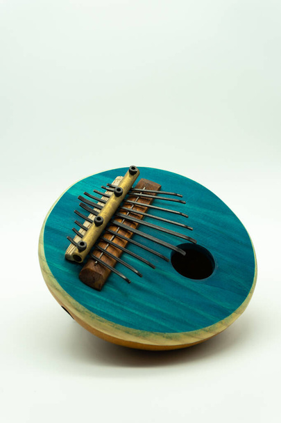Blauw Houten etnisch Afrikaans instrument Kalimba close up. Witte achtergrond. Muziekconcept. - Foto, afbeelding