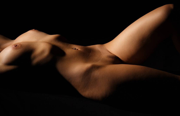 naked young woman with sexy body on black background - Zdjęcie, obraz