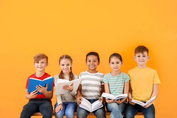 Милі маленькі діти читають книги на кольоровому фоні
 - Фото, зображення