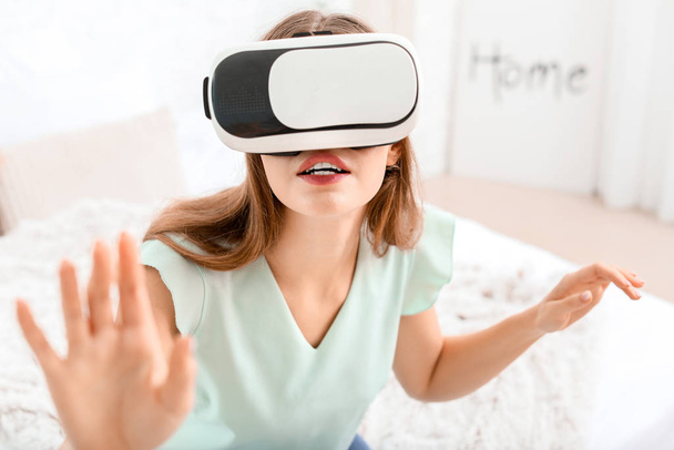 Νεαρή γυναίκα με γυαλιά εικονικής πραγματικότητας στο σπίτι - Φωτογραφία, εικόνα