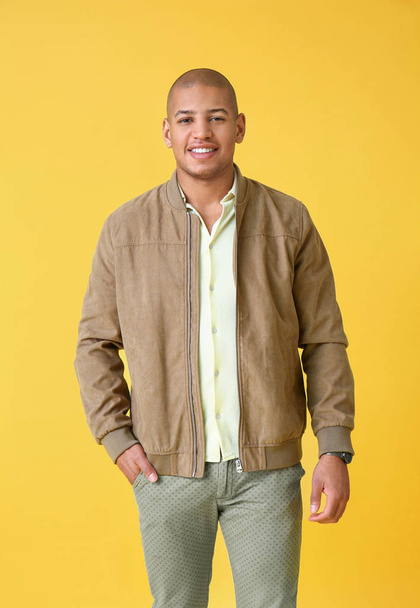 Stylish African-American man on color background - Foto, imagen