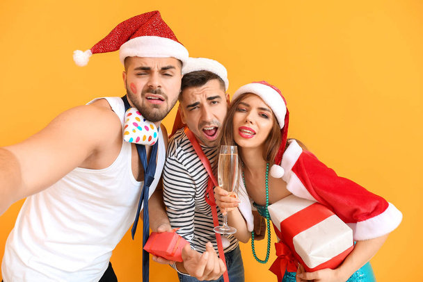 Humalaiset ystävät ottavat selfien juhliessaan uutta vuotta väritaustaa vasten
 - Valokuva, kuva