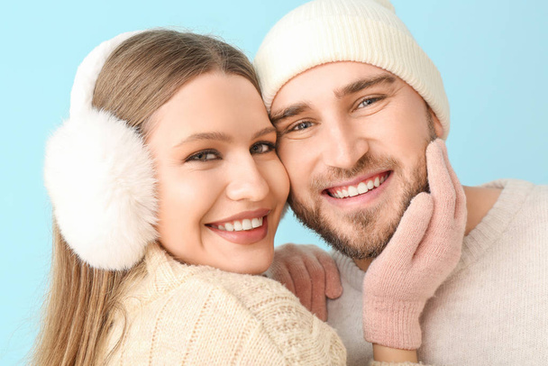 Portrait de couple heureux en vêtements d'hiver sur fond de couleur
 - Photo, image