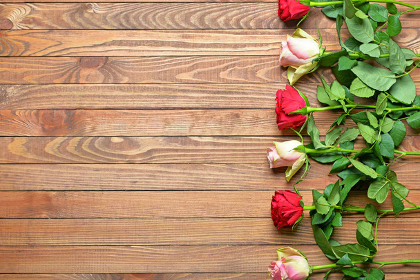 Beautiful rose flowers on wooden background - 写真・画像