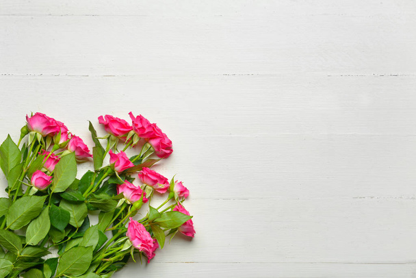 Hermosas flores de rosa sobre fondo de madera blanca
 - Foto, imagen