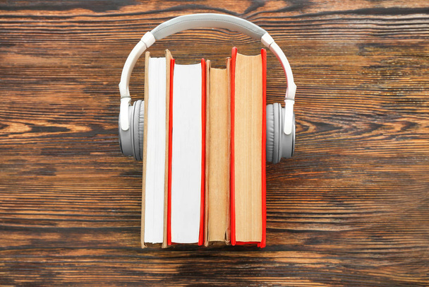 Libros y auriculares modernos sobre fondo de madera. Concepto de audiolibro
 - Foto, imagen