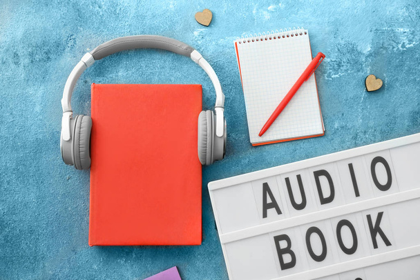 Book and modern headphones on color background. Concept of audiobook - Photo, Image