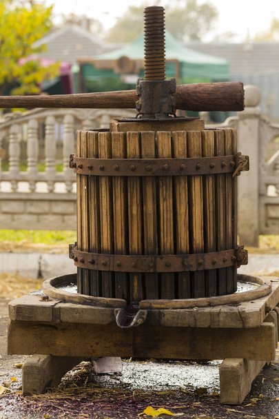 De pers wordt gebruikt om de wijn te persen. Technologie van de wijnproductie in Moldavië. De volkstraditie van wijn maken. De oude traditie van druivenverwerking. Oogst thuis. - Foto, afbeelding