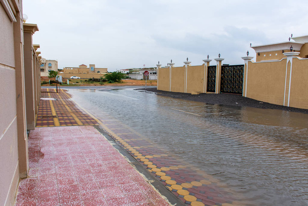 Ein stürmischer Tag in den Vereinigten Arabischen Emiraten hinterlässt Überschwemmungen in den Wohngebieten der Stadt ras al khaimah und der umliegenden Emirate. Keine Schule. überflutete Straße. Wetterkonzept. - Foto, Bild
