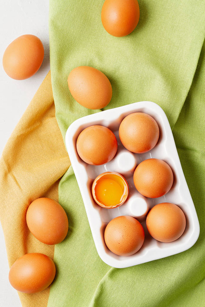 Eieren, handdoek in rustieke stijl op lichte ondergrond. Biologisch ingrediënt, gezonde levensstijl concept. Pasen achtergrond. Vlakke lay, kopieerruimte - Foto, afbeelding