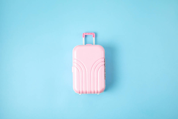 Miniature pink suitcase. Travel preparation, tourism, hand luggage, low cost flights, vacations baggage packing concept - Valokuva, kuva