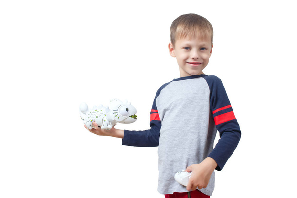 Увлеченный мальчик играет в игрушечного робота-ящерицу с дистанционным управлением, изолированного на белом фоне. Нано-игрушка Хамелеон выплюнула язык в ребенка. Современные технологии игрушек
. - Фото, изображение