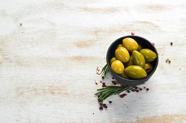 Pickled olives in a black bowl. Top view. Free space for your text. - Foto, Bild