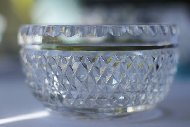 Makro-Ansicht einer schönen Vintage handgefertigten Bleikristallglasschale mit diamantgeschliffenen Facetten, die brillantes natürliches Licht reflektieren - Foto, Bild