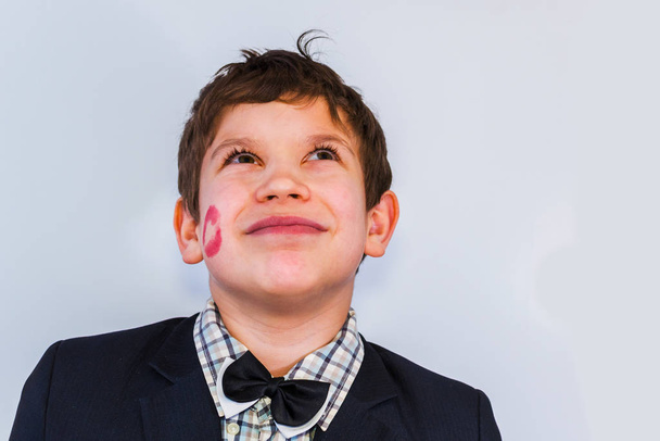 portrét dospívajícího chlapce s otiskem rtěnky na tváři - Fotografie, Obrázek